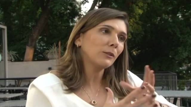 Diana Delnegro during the TV Bandeirantes interview, outdoors, explaining the project.