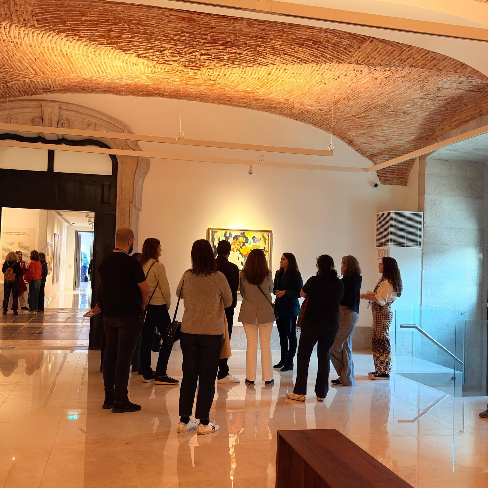 A MACAM gallery with the works lit and visitors crossing the room during the guided tour.