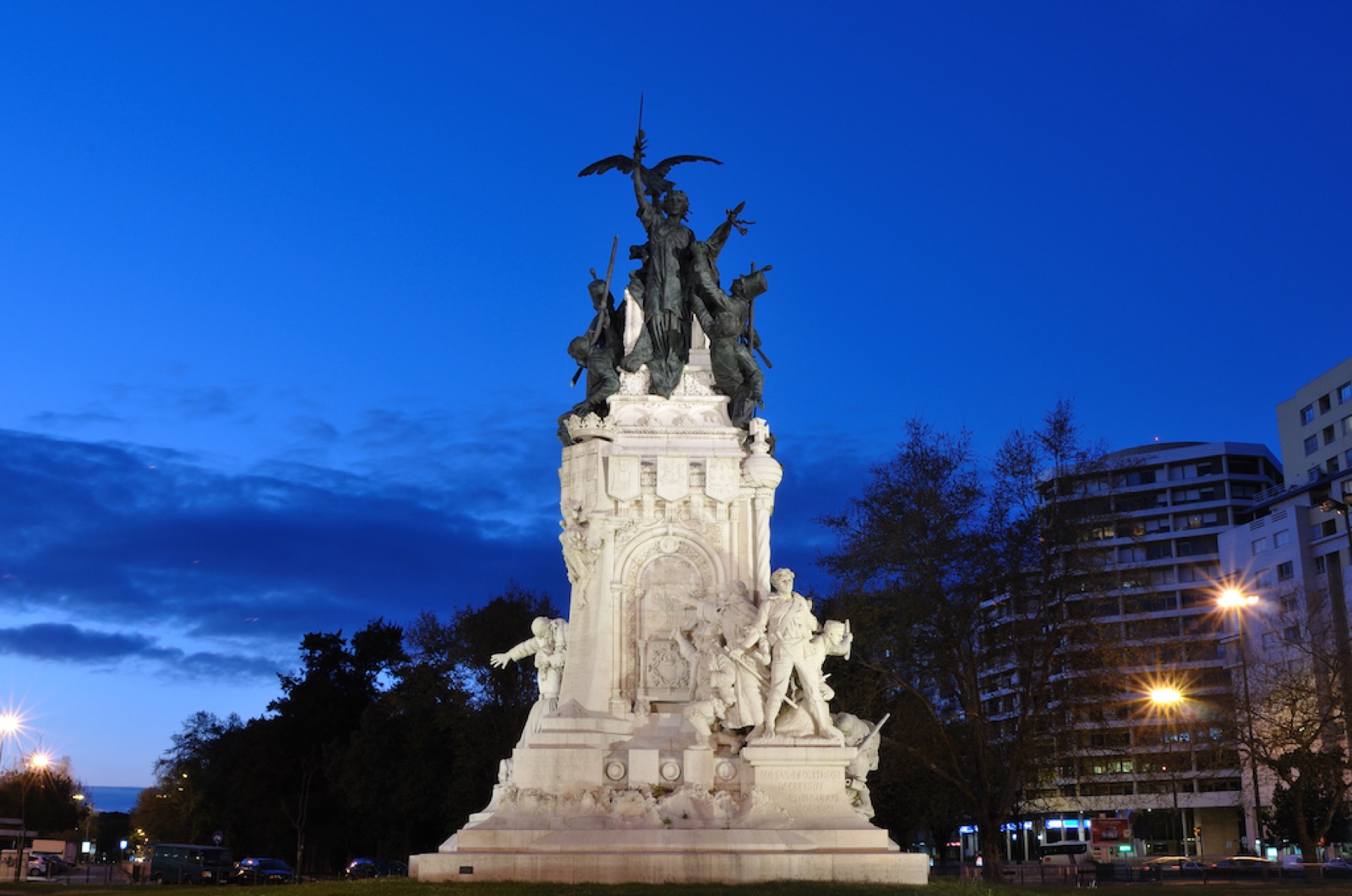 The Entrecampos statue lit at the centre of the roundabout.