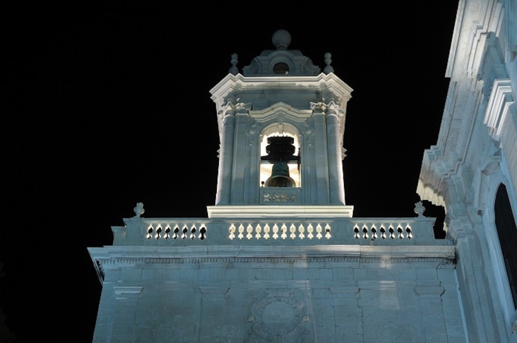 The bell tower of the Graça church lit above the viewpoint.