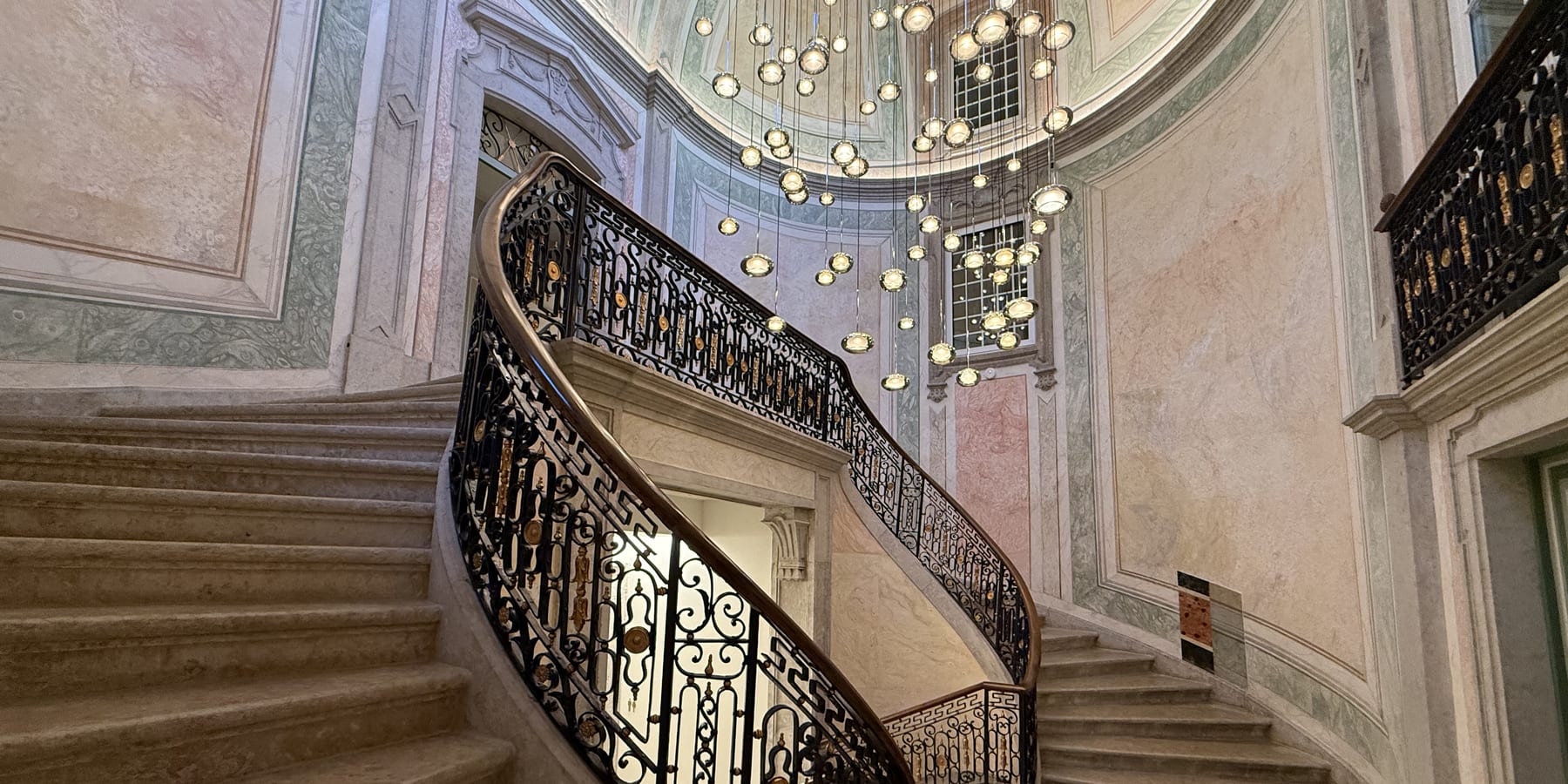 The state staircase of the MACAM palace, a cascade of crystal globes falling from the dome over the wrought-iron balustrade.