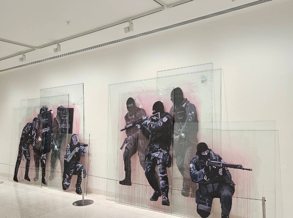The overlapping glass panels, the painted figures throwing their own shadow onto the white wall behind and the light crossing the glass without lighting it up.