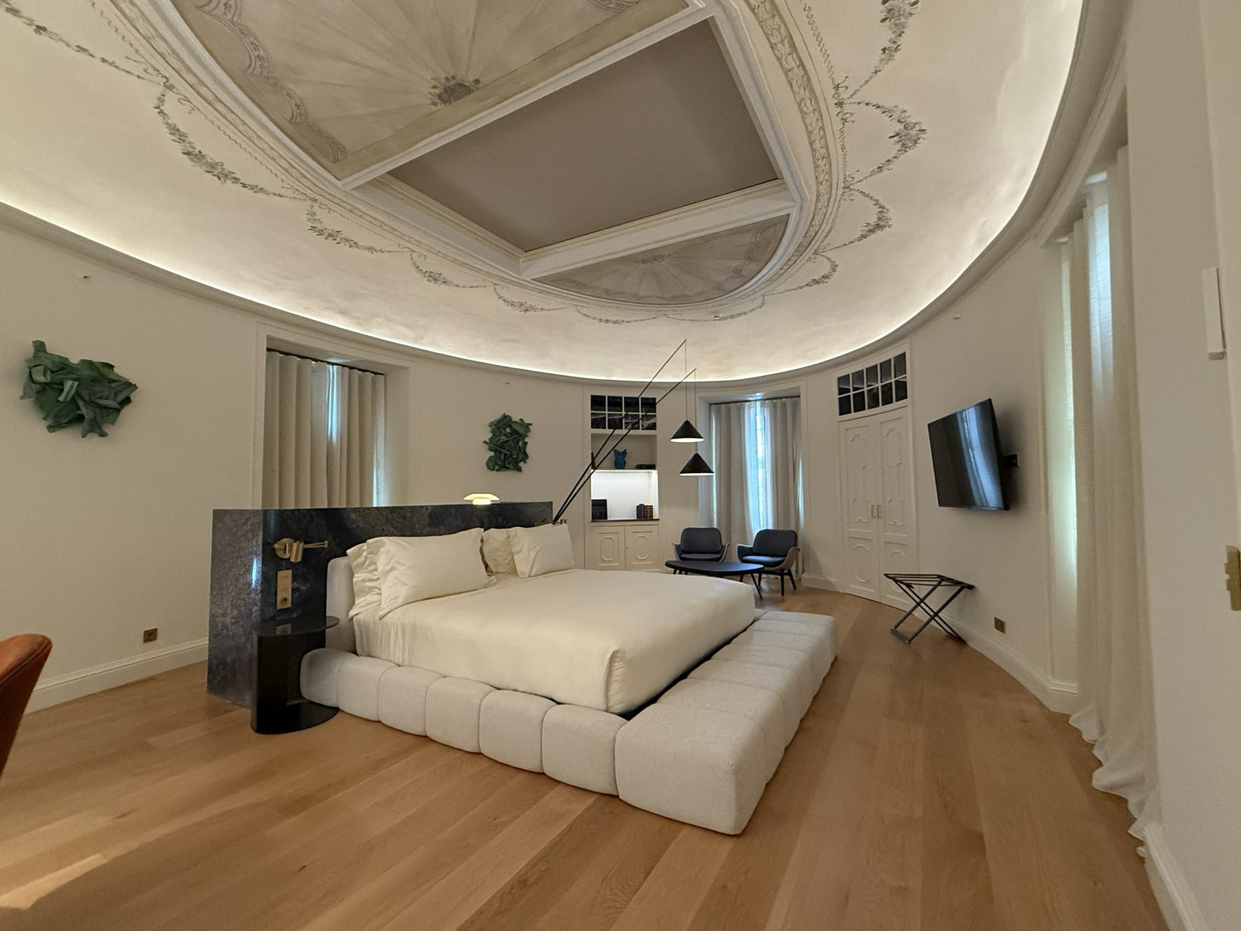 The principal suite beneath its painted nineteenth-century dome, lifted by a continuous cove of light.