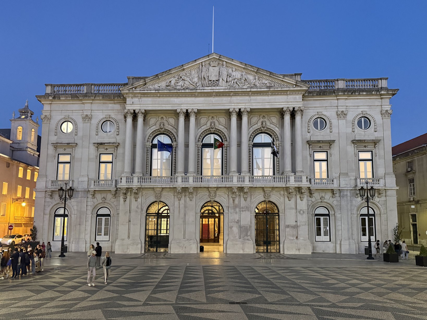 La fachada de los Paços do Concelho con la iluminación anterior, al anochecer: una luz plana y uniforme, sin nada que destaque la columnata ni el balcón.